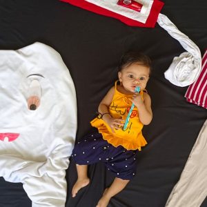 baby lying among clothes