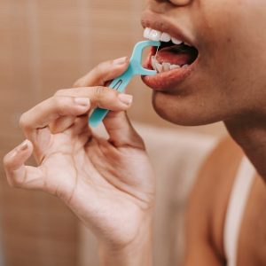 ethnic woman cleaning teeth with dental floss