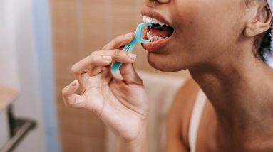 ethnic woman cleaning teeth with dental floss